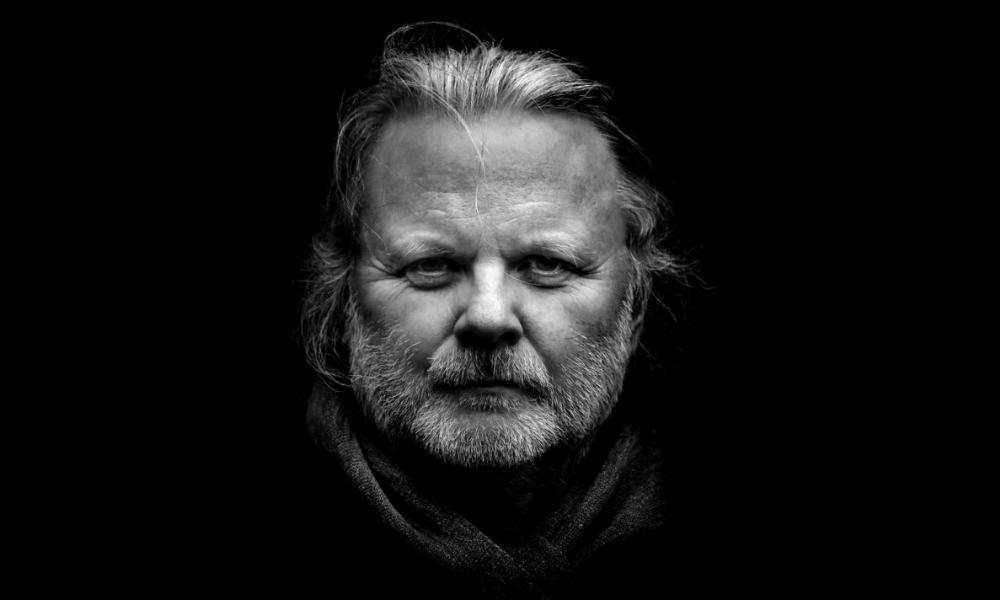 Black and white portrait of Norwegian author and 2023 Nobel Prize for Literature recipient Jon Fosse staring directly at the camera.